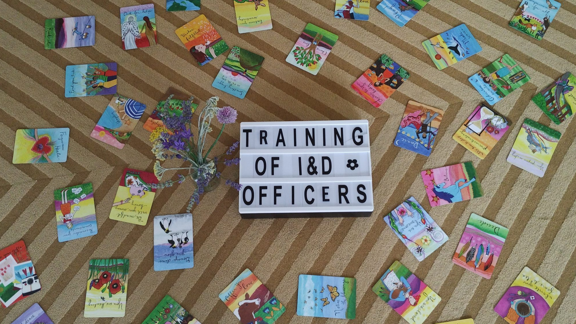 A photo of colorful cards and a sign that says "Training of I&D Officers"
