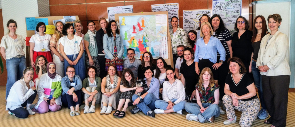 A group photo of the participants of the 8th Meeting of Inclusion and Diversity Officers in front of a map of Europe.