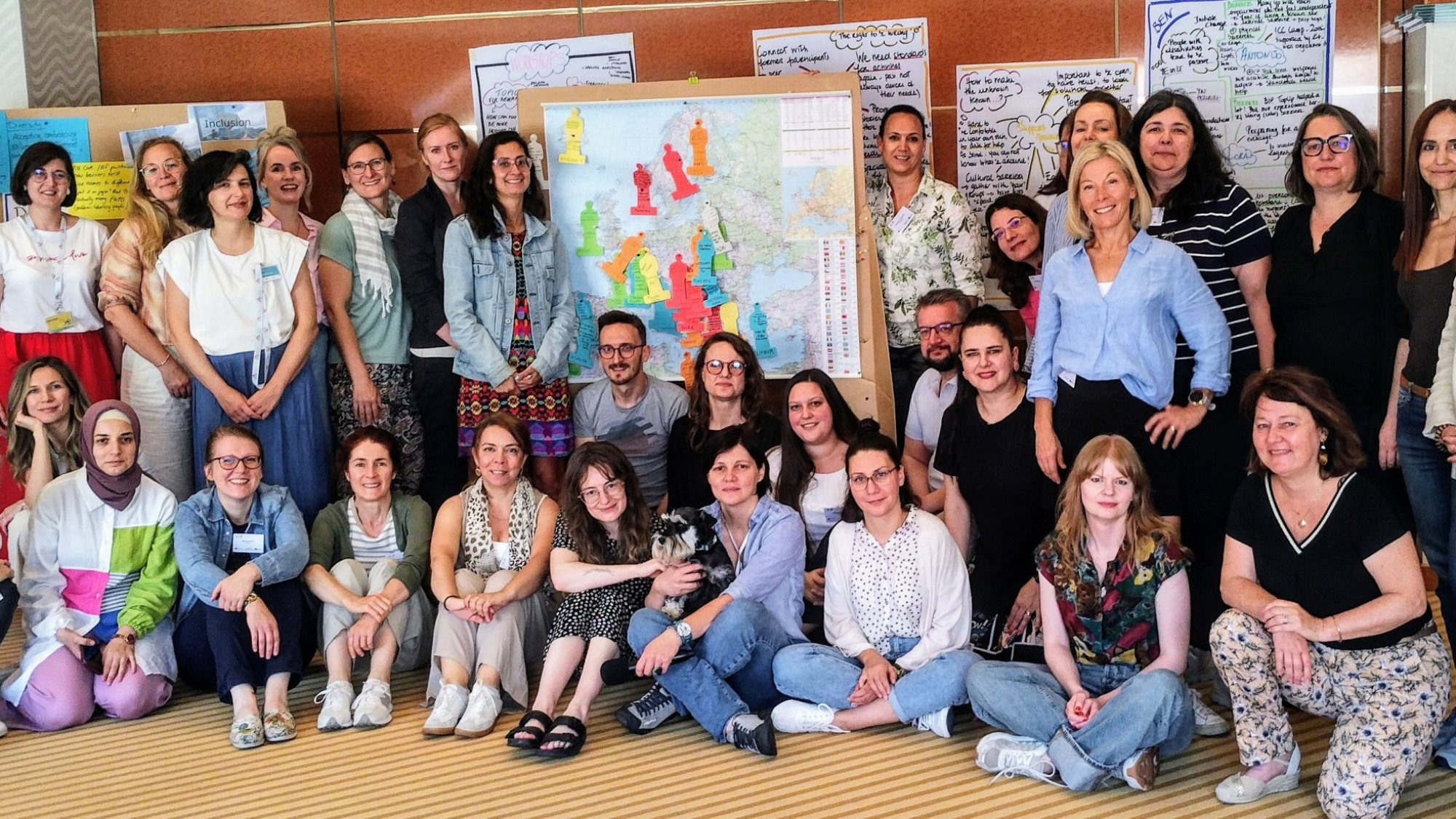 A group photo of the participants of the 8th Meeting of Inclusion and Diversity Officers in front of a map of Europe.