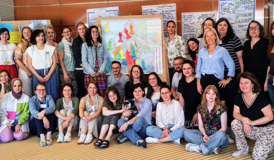 A group photo of the participants of the 8th Meeting of Inclusion and Diversity Officers in front of a map of Europe.