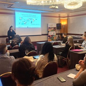 A group of people sitting and listening to a Power Point presentation given by a woman, titled "Getting to Know the SALTO Resources".