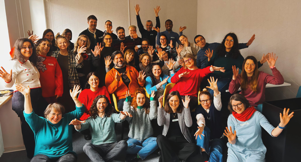 A group of people merrily holding their hands up.
